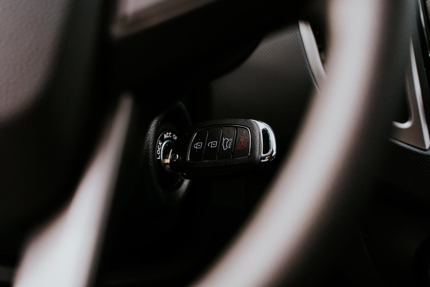 Modern car key fob inserted in vehicle ignition cylinder showing automotive locksmith service subject
