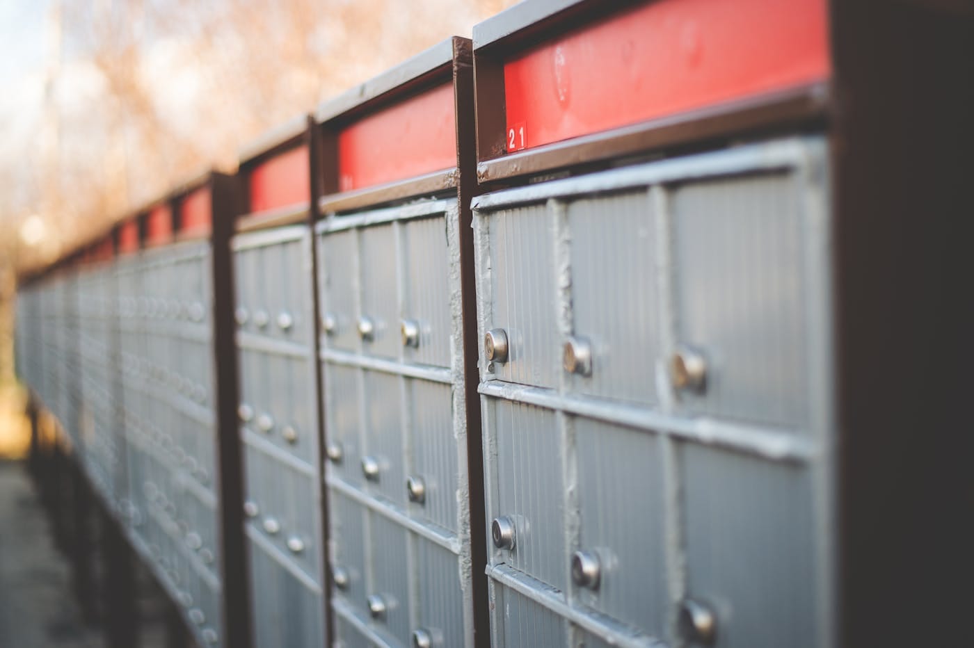 Row of residential cluster mailboxes with individual lock cylinders showing mail security infrastructure