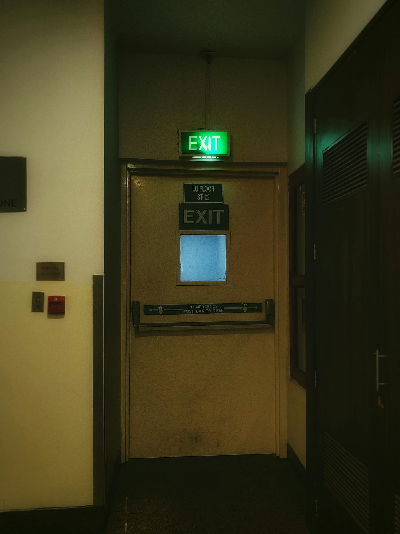 Exit door and illuminated signs in a dim corridor