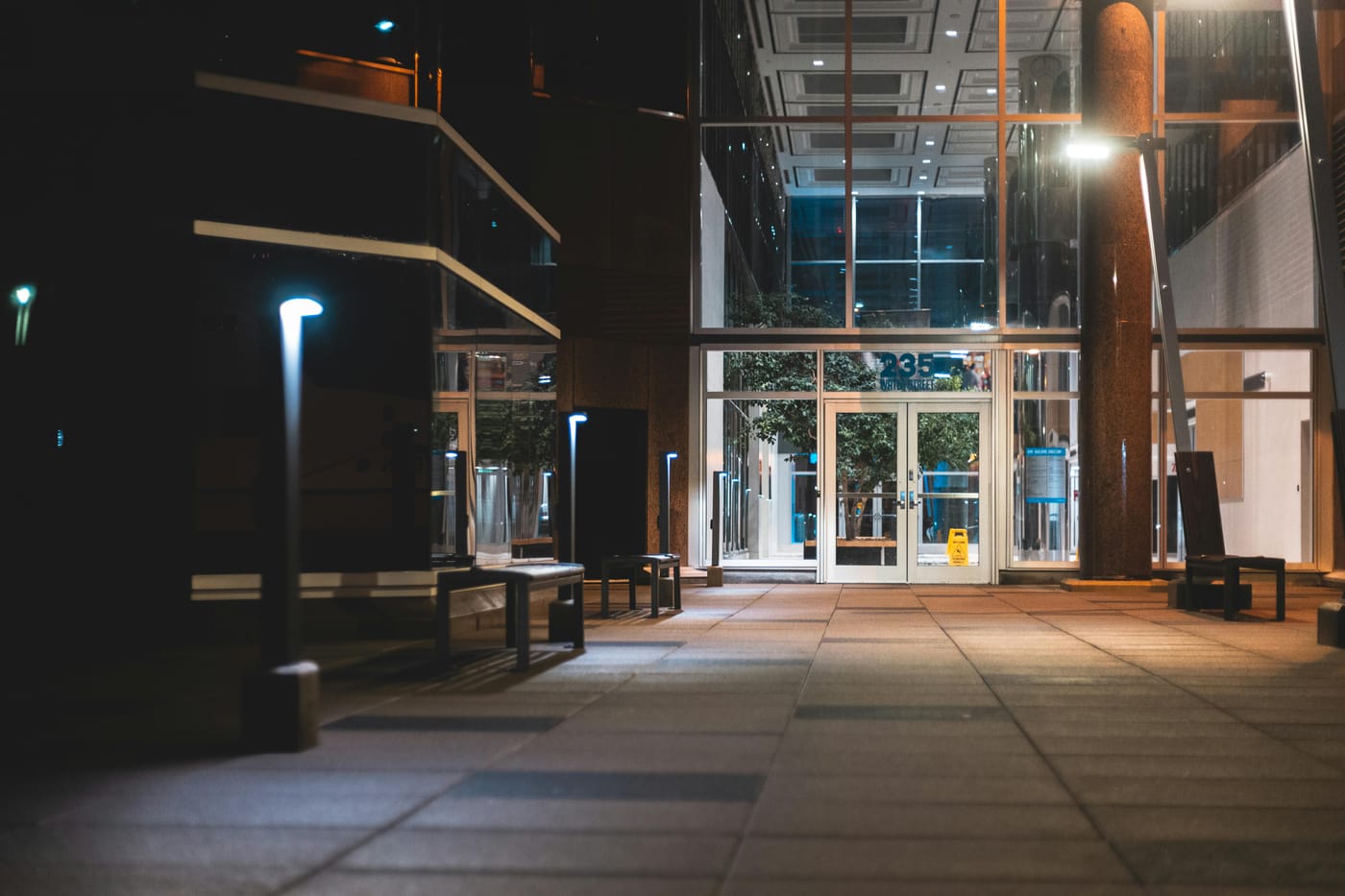 Illuminated glass entrance and walkway at night