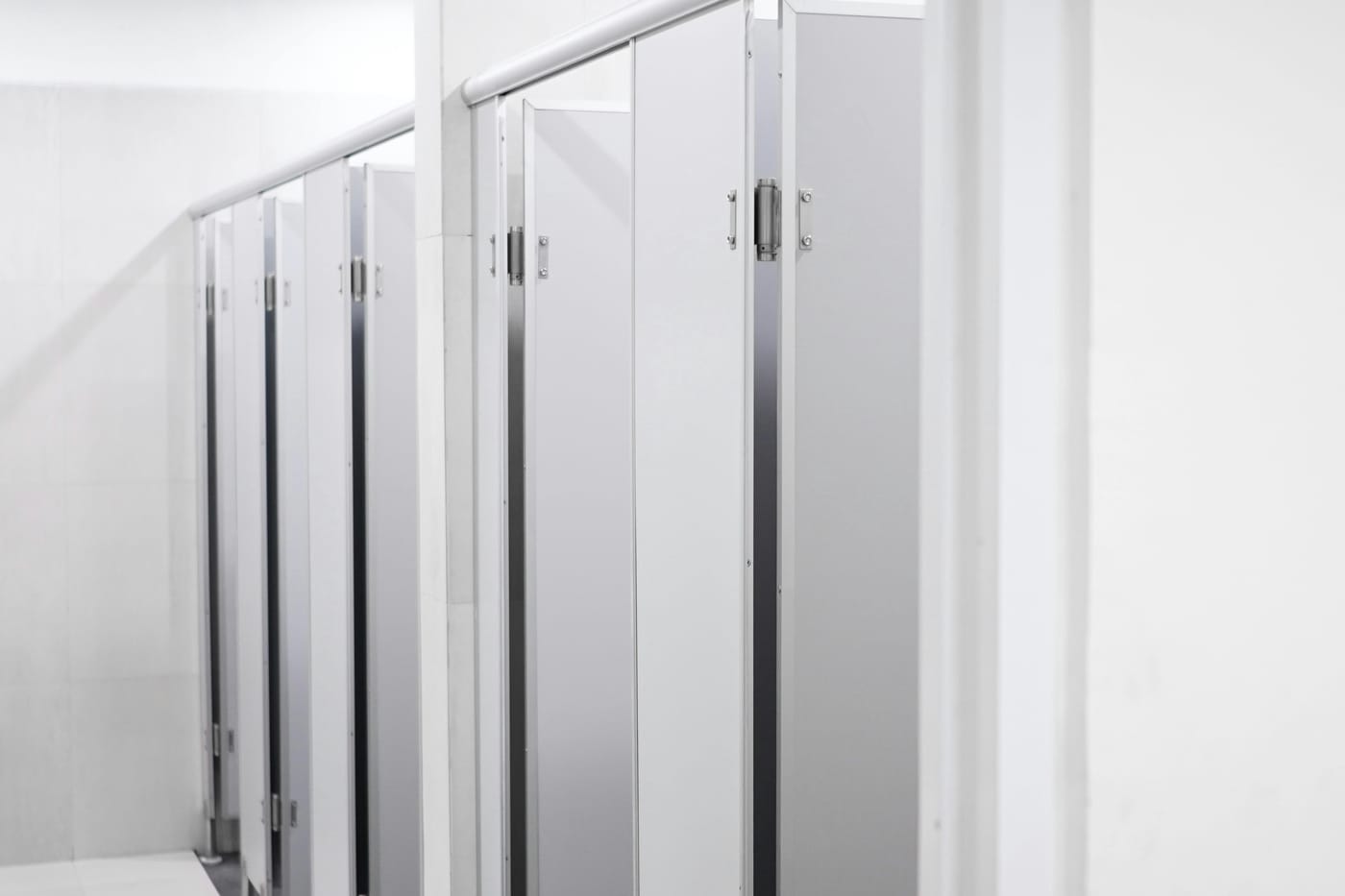 Row of light-colored restroom cubicle doors