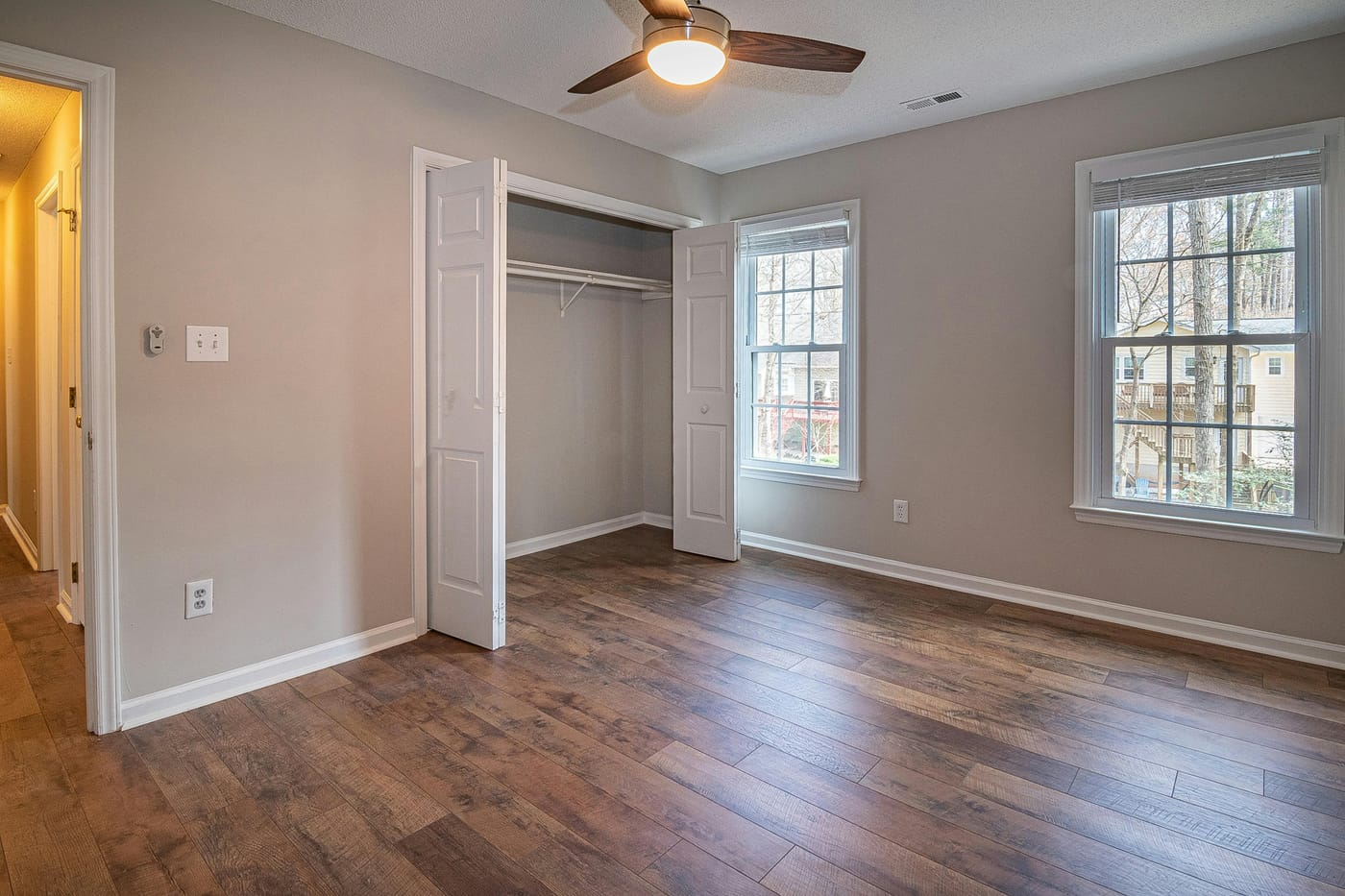 Empty bedroom with an open closet and ceiling fan