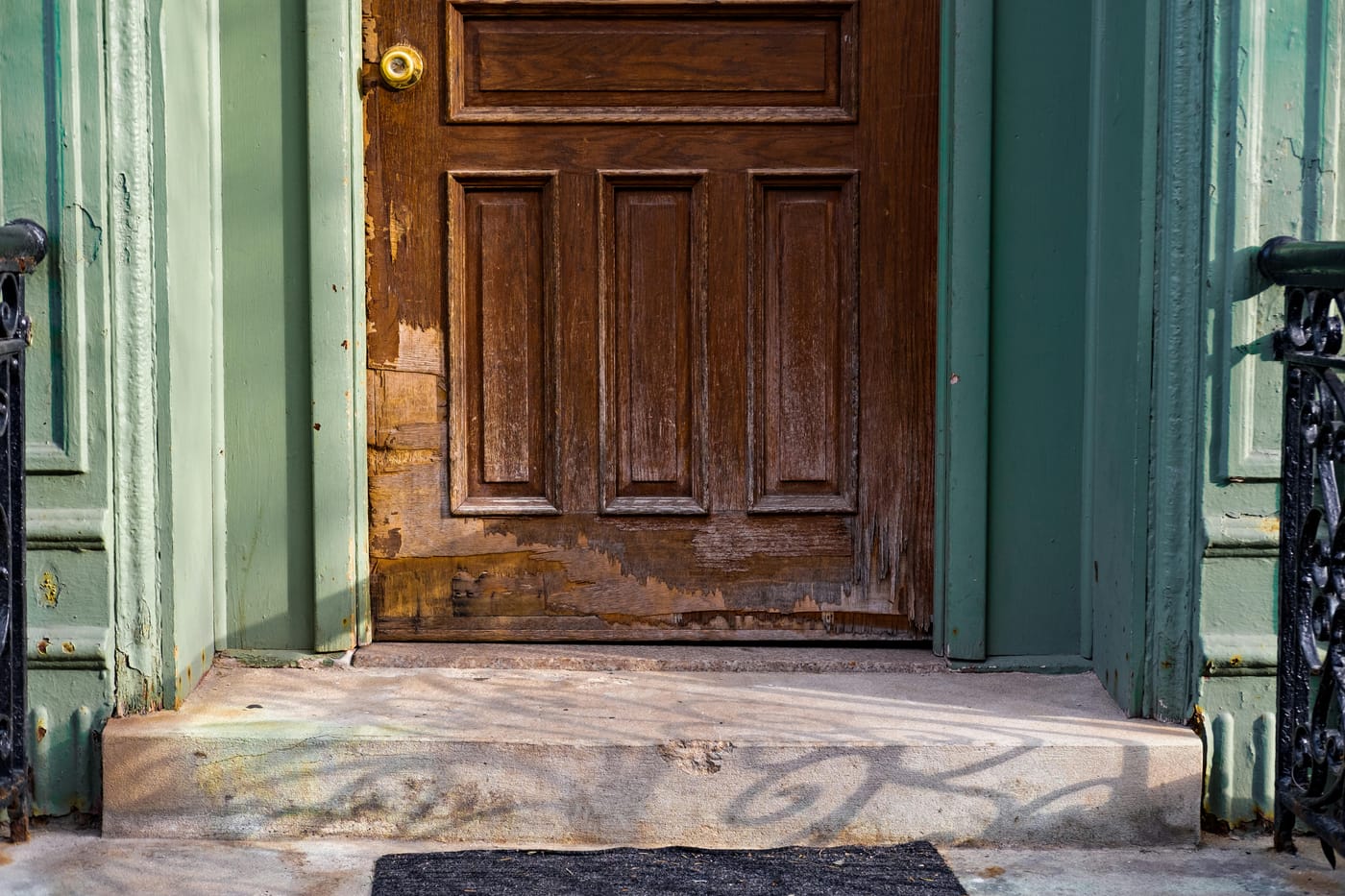 Weathered wooden door in a green-painted frame