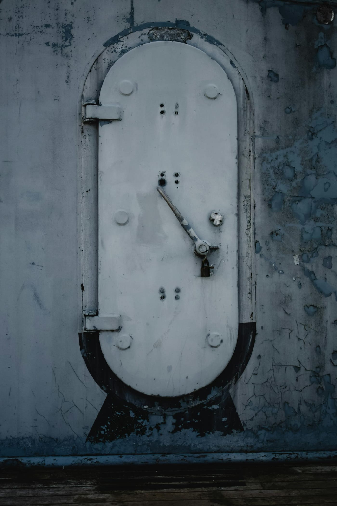 Weathered heavy metal hatch in a concrete wall