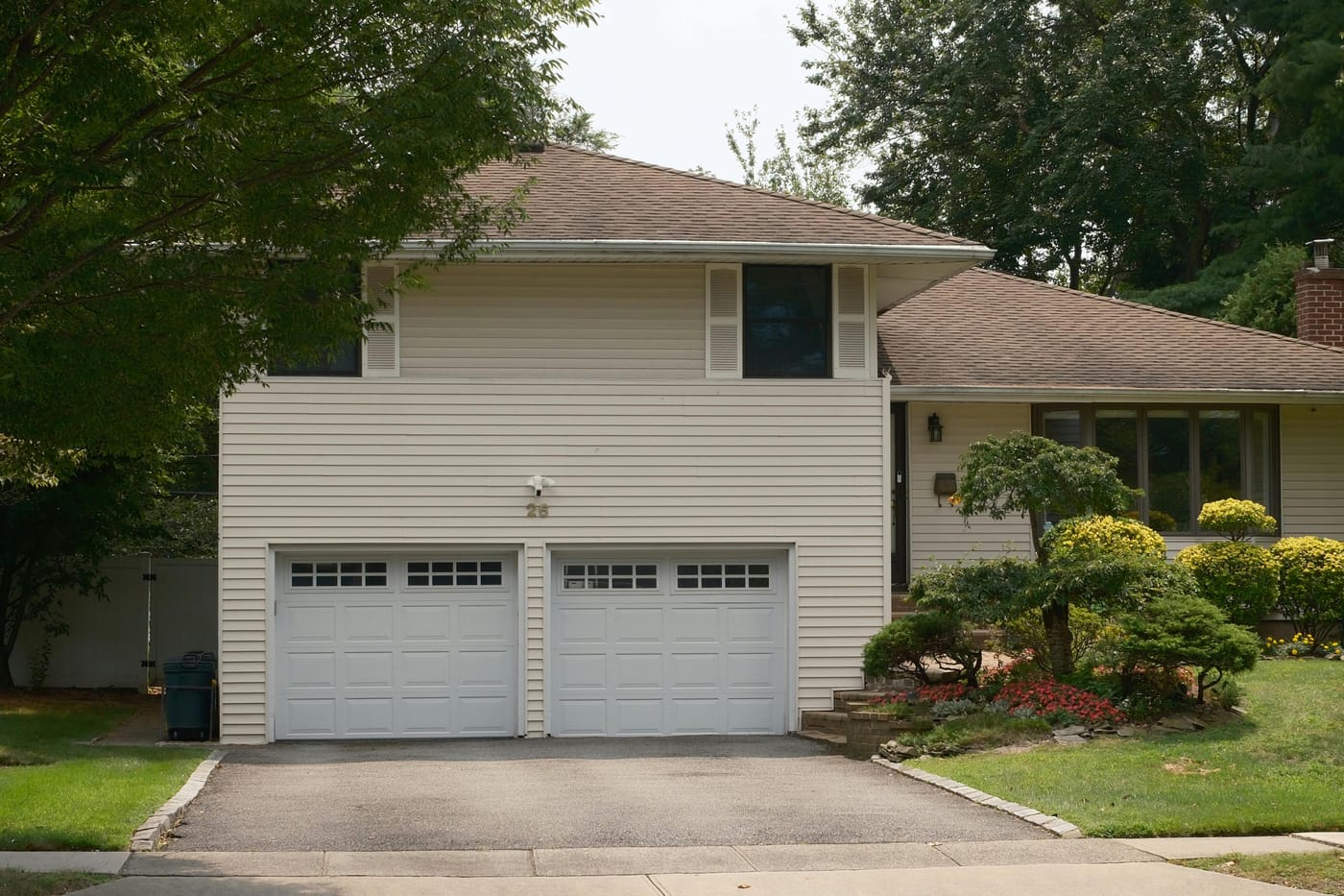 House with two white garage doors and a driveway