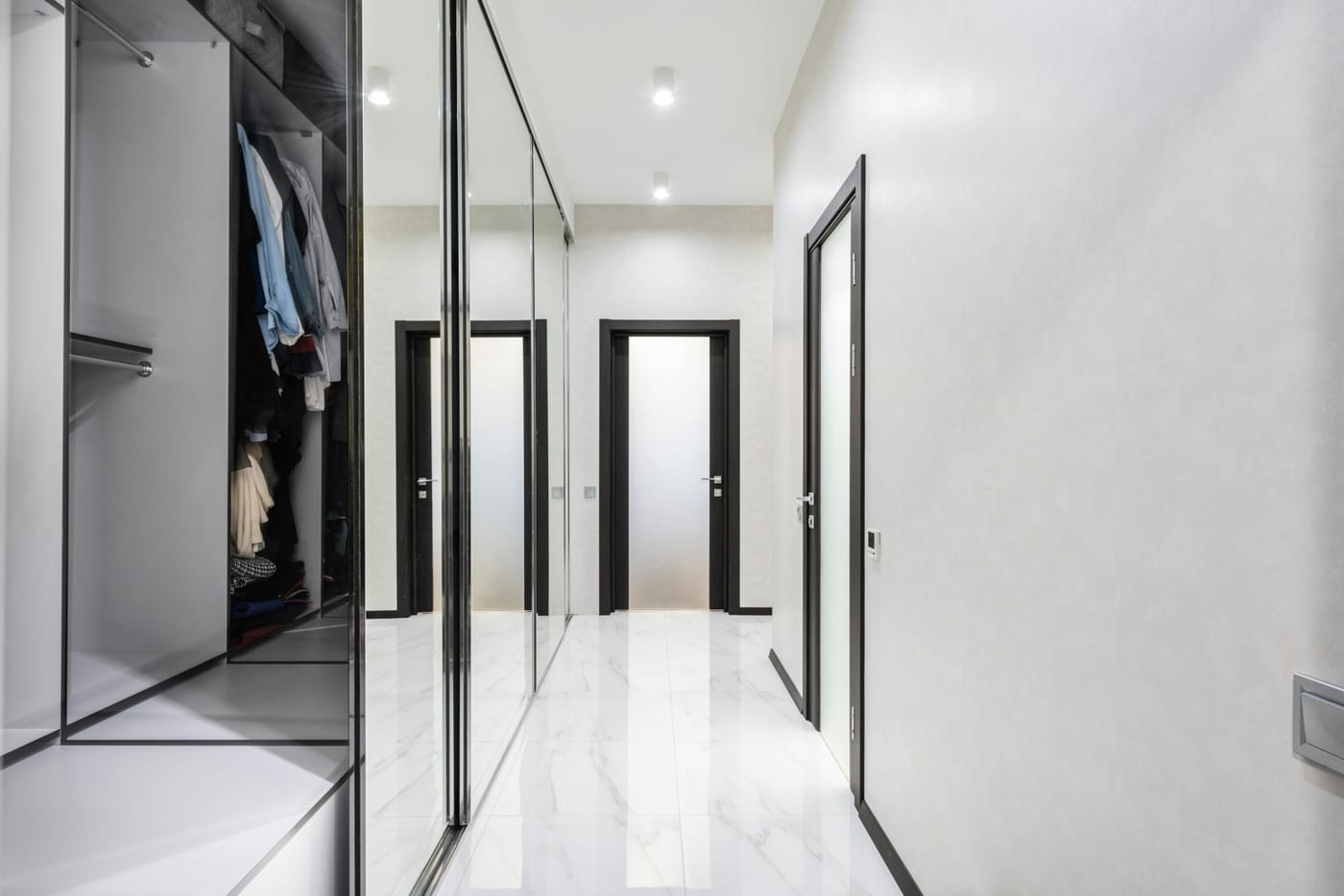 Bright walk-in closet with mirrored sliding doors