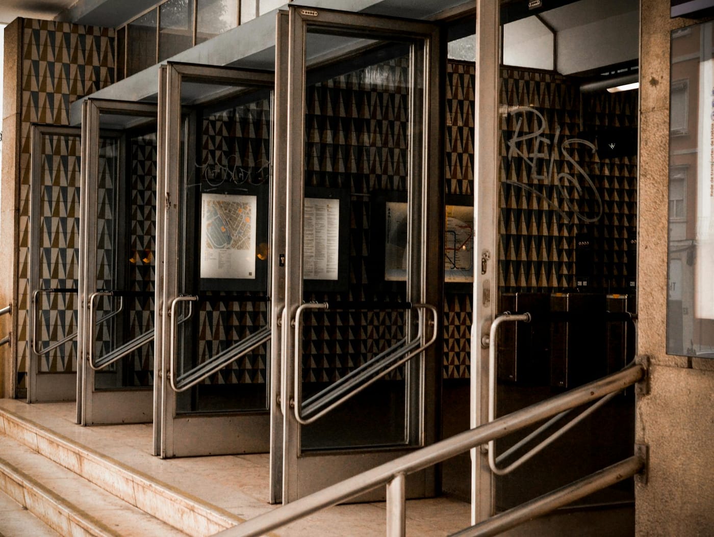 Metal-framed glass entrance with steps and handrails