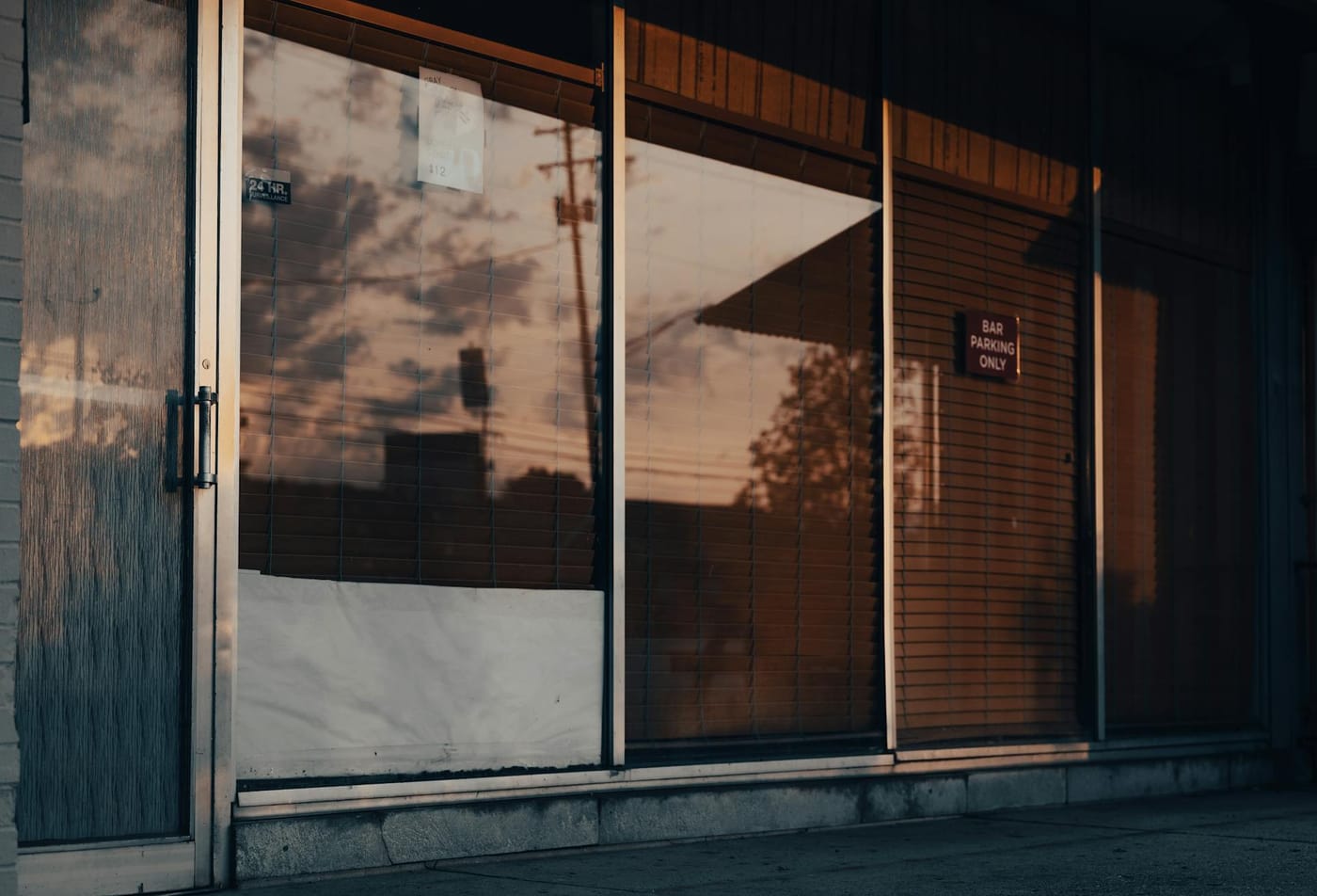 Closed glass double doors reflecting trees