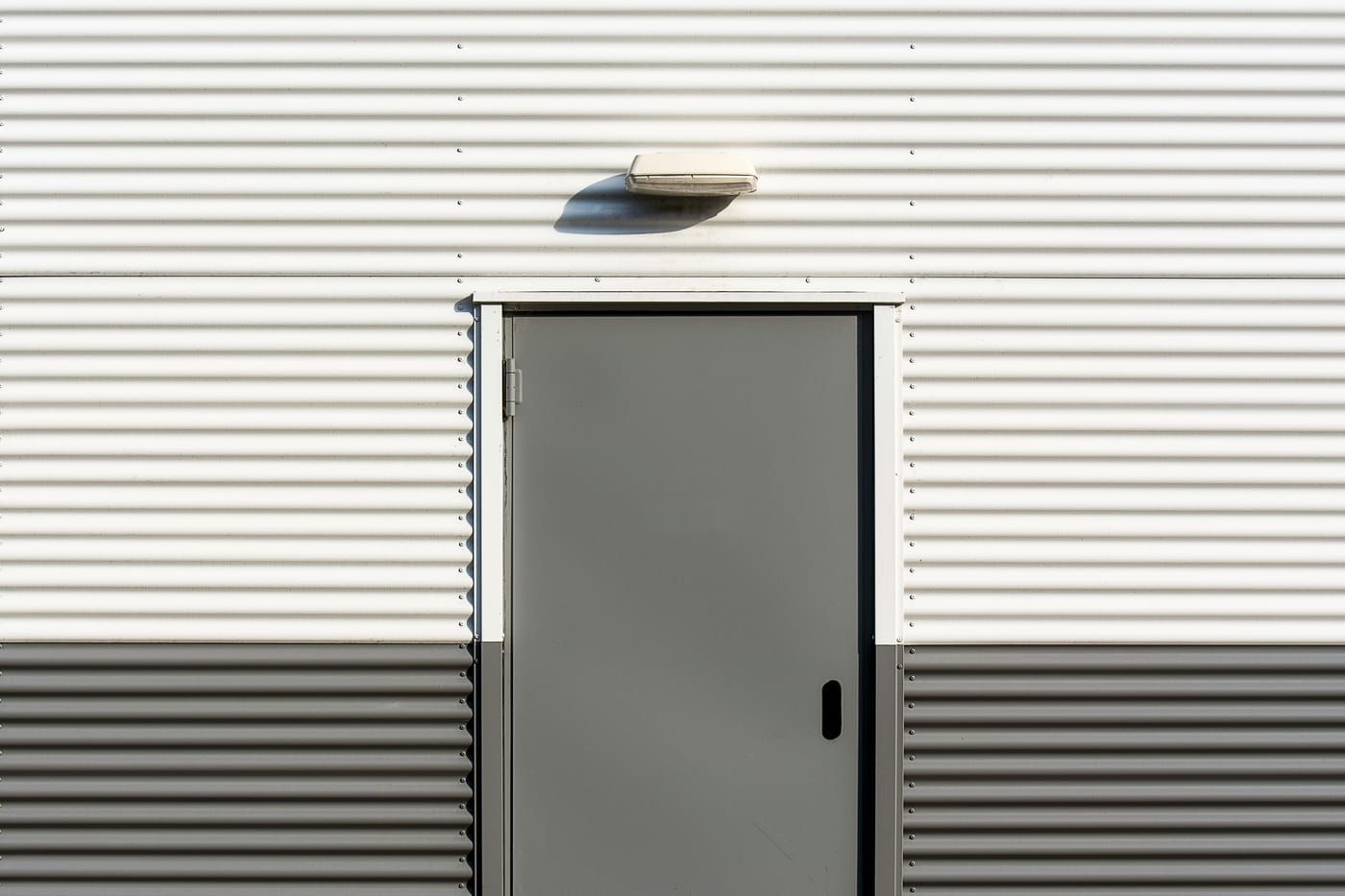 Plain metal service door in corrugated siding