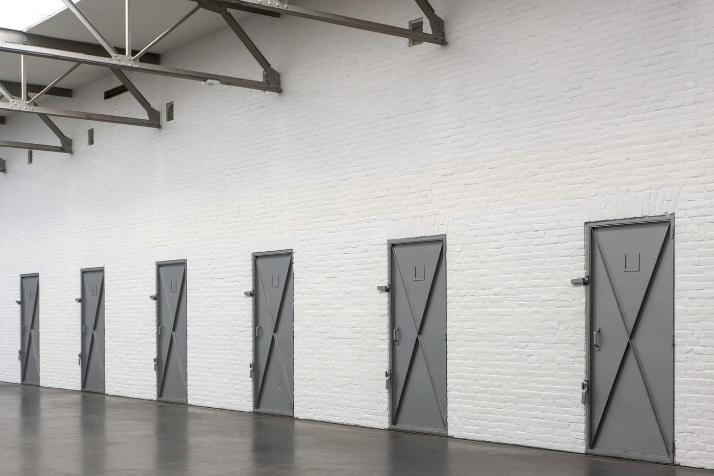 Row of closed metal doors along a warehouse wall