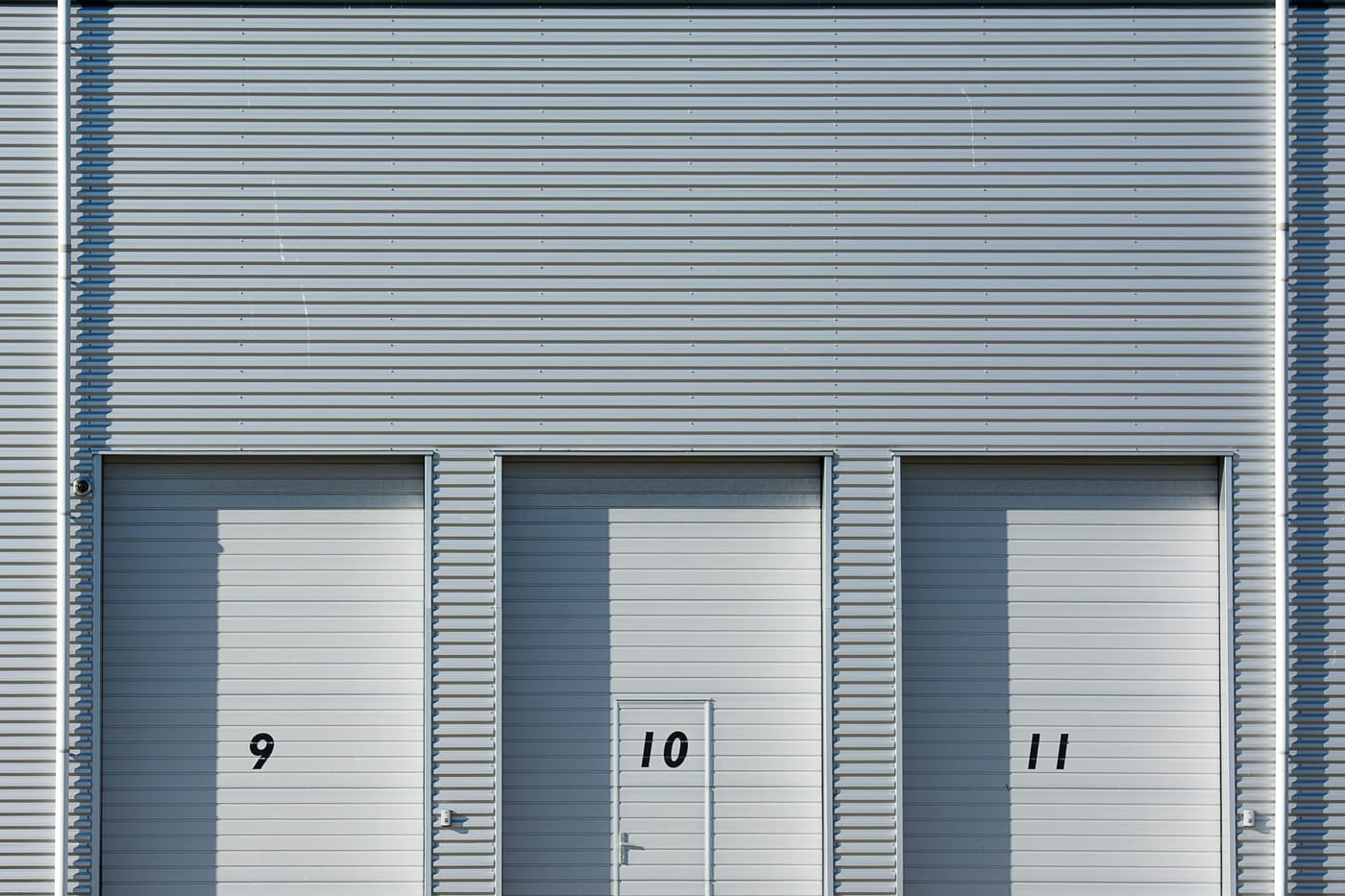 Numbered roll-up doors on an industrial facade