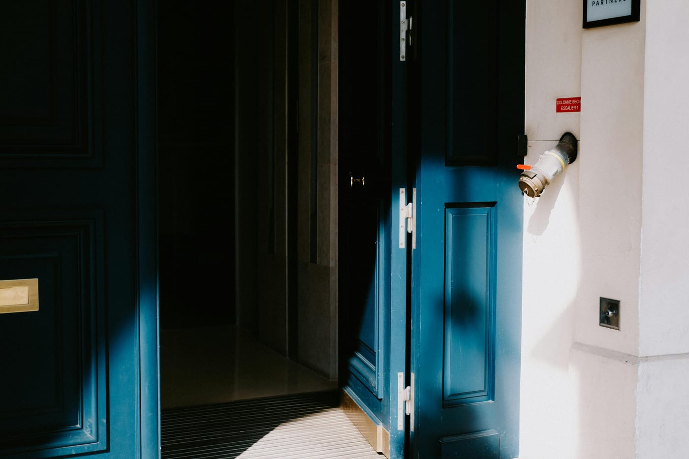 Blue paneled door standing partly open