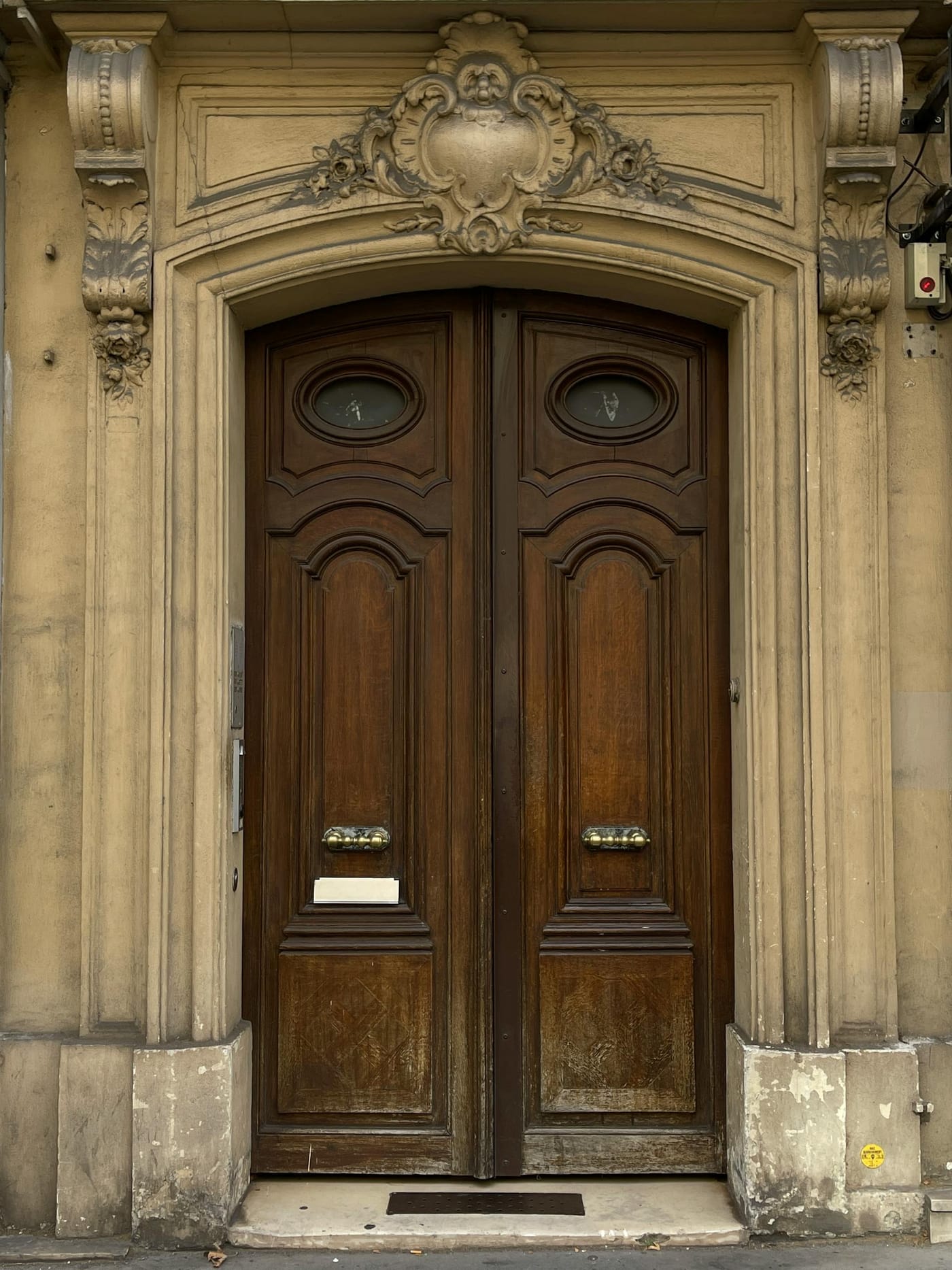 Ornately carved wooden double doors in a stone facade