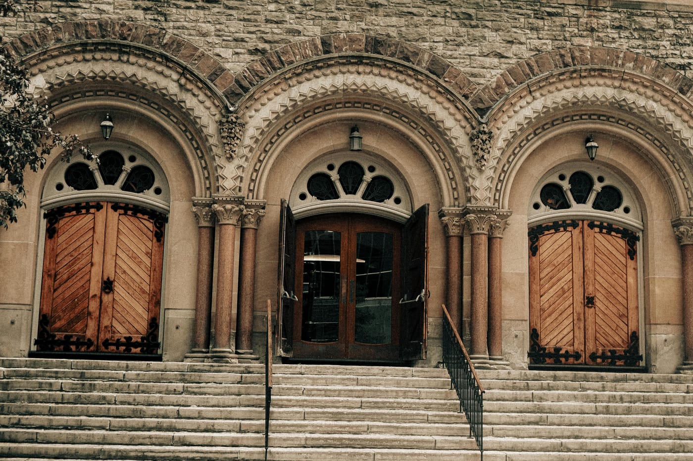 Arched stone entrance with wooden doors and broad steps