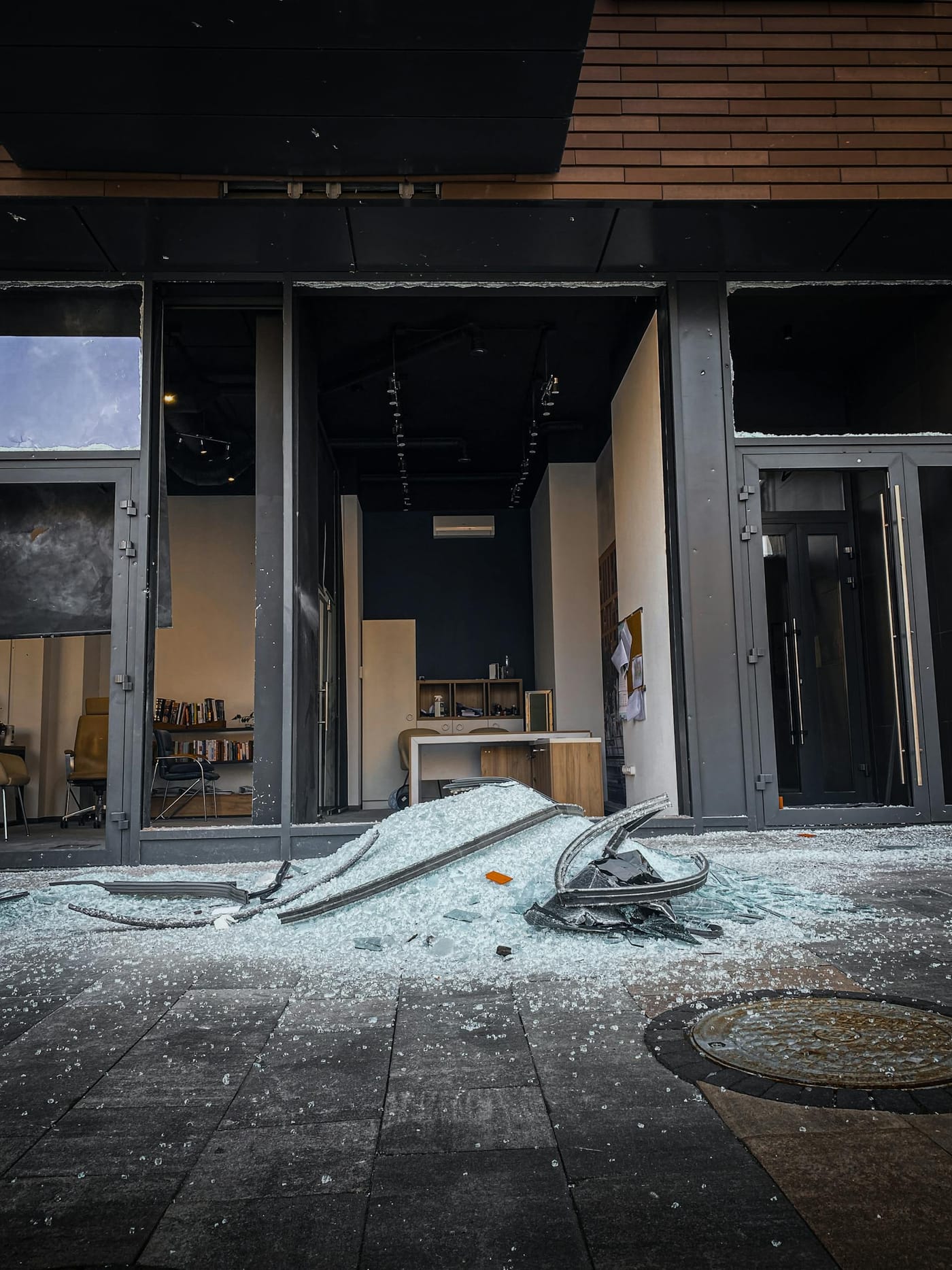 Broken glass scattered outside a damaged shop entrance