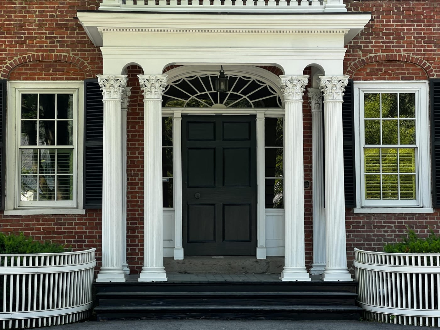 Black double entrance doors framed by white columns