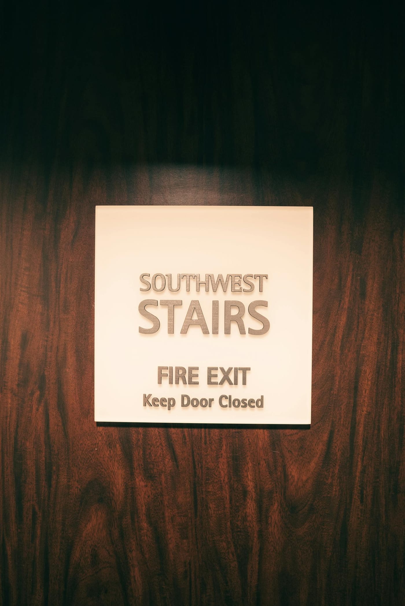 Fire-exit sign on a wooden stairwell door