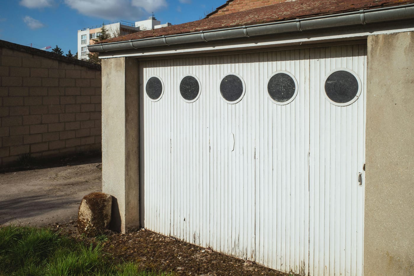 White garage door with a row of circular windows