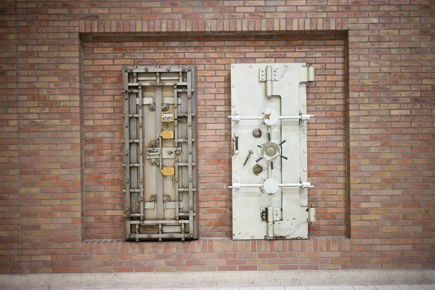 Two old steel vault doors in a brick wall
