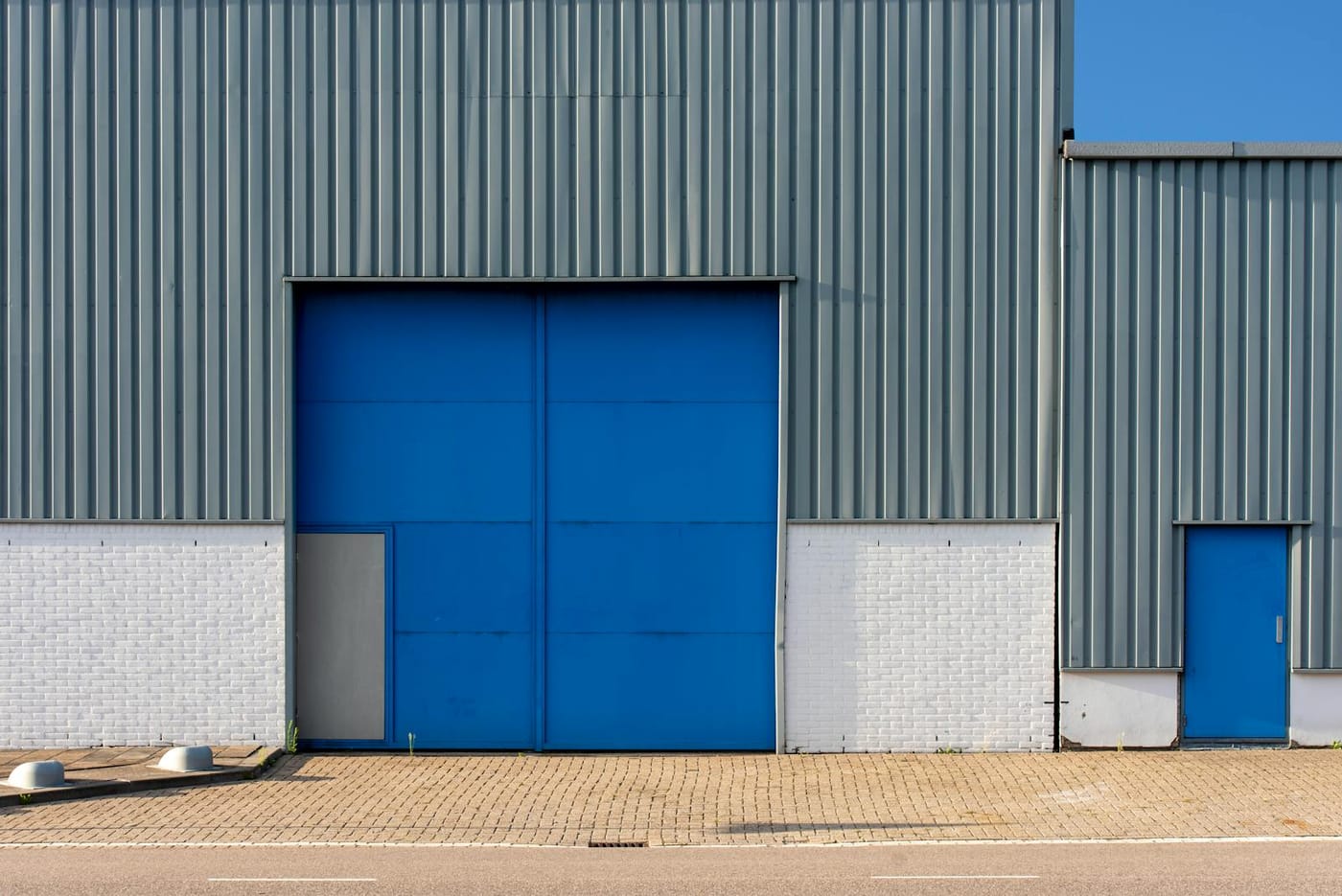 Blue industrial door in a metal-clad warehouse