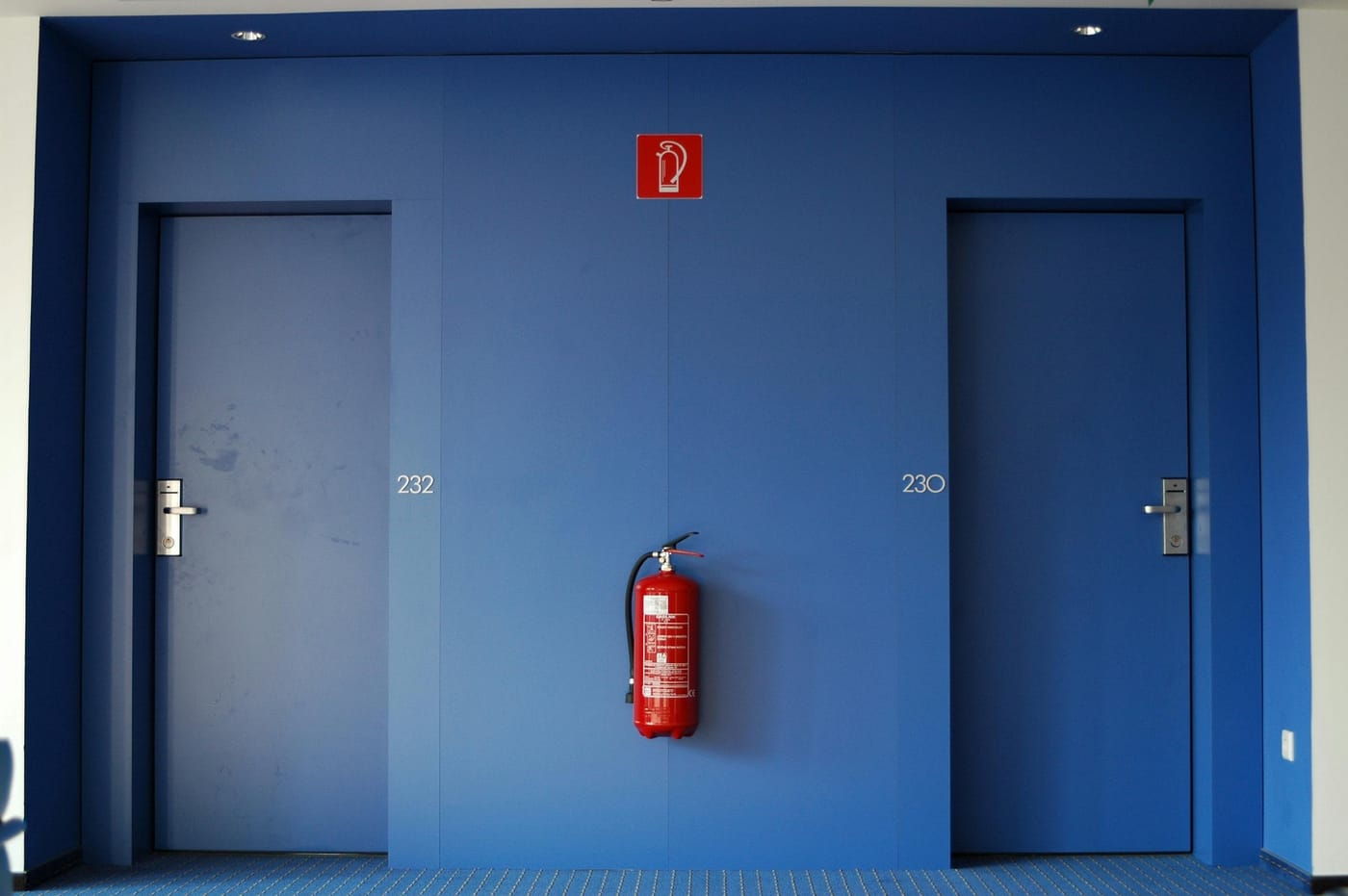 Two blue doors with a fire extinguisher mounted between them