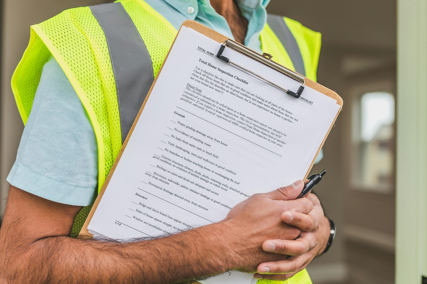 Person in a reflective vest holding an inspection clipboard