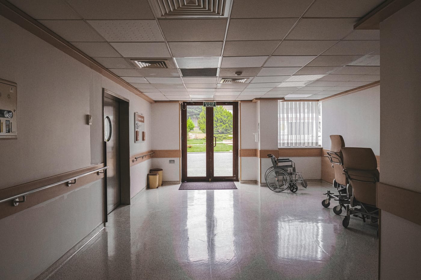 Healthcare corridor with handrails and parked wheelchairs