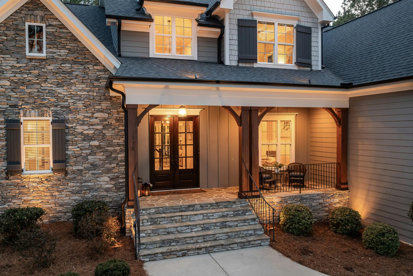 Stone and siding house with an illuminated front entrance