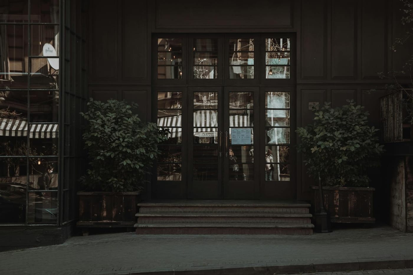 Dark wooden shop entrance with potted plants