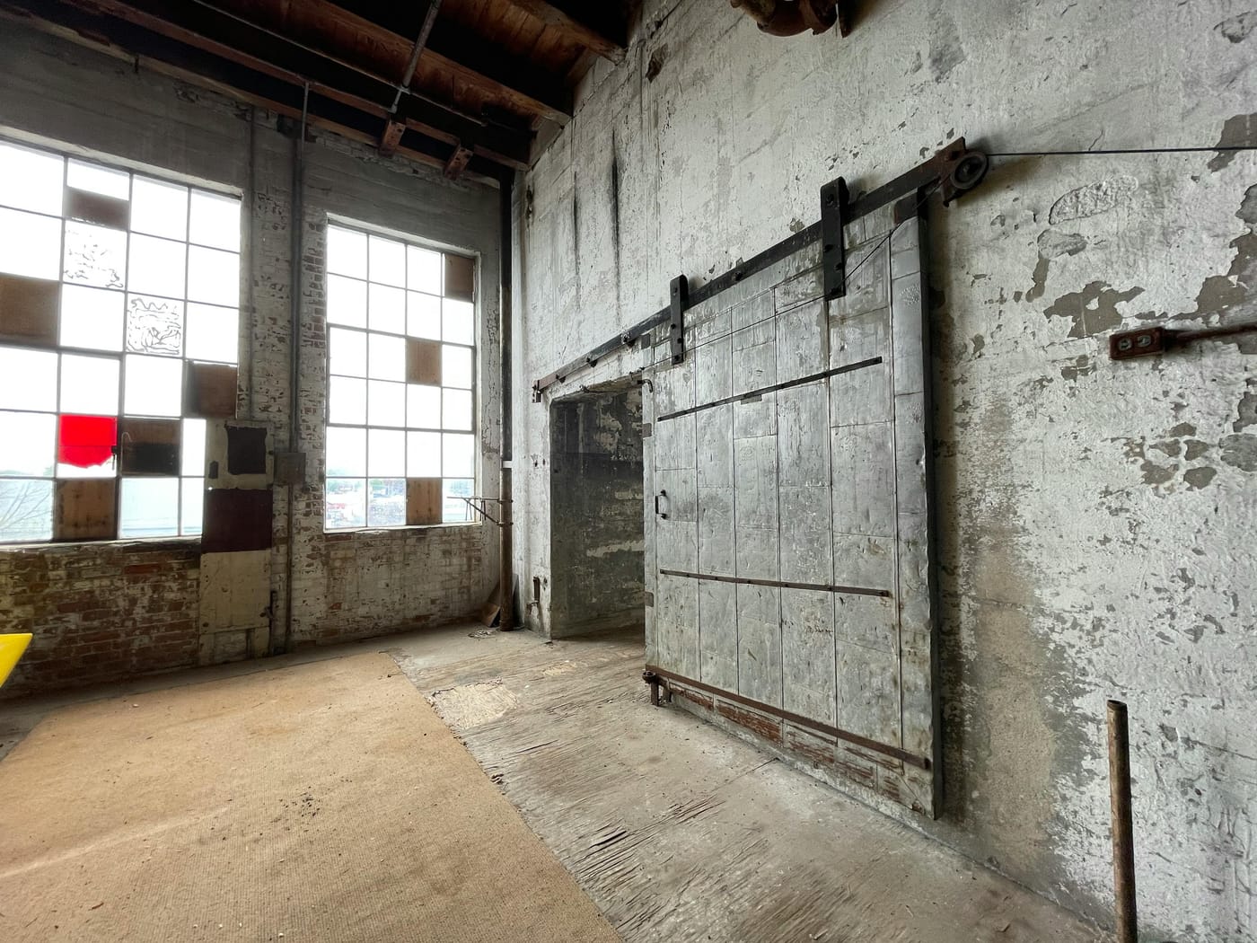 Large sliding industrial door in a worn brick workshop