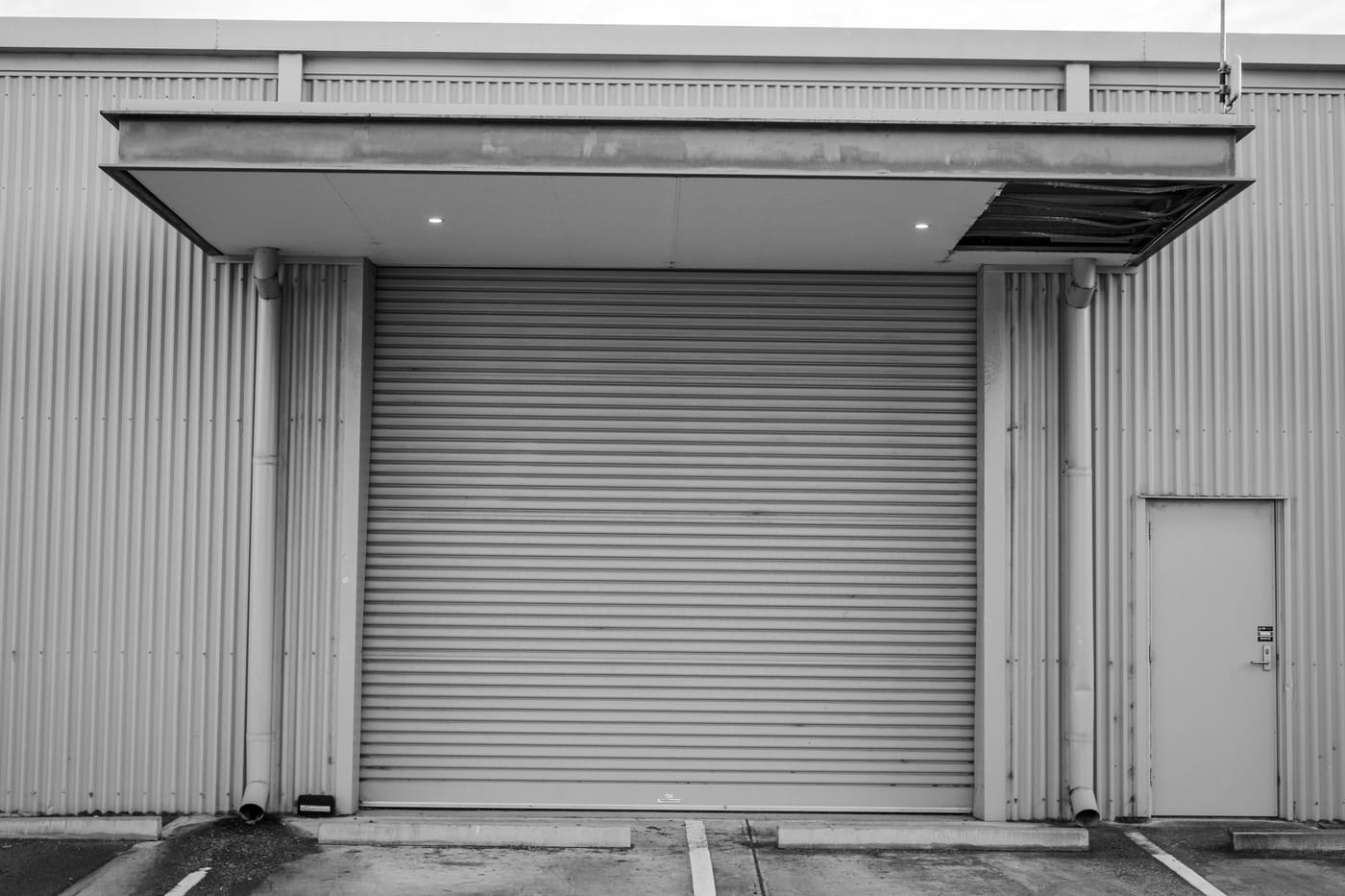 Closed metal roll-up door beneath a canopy