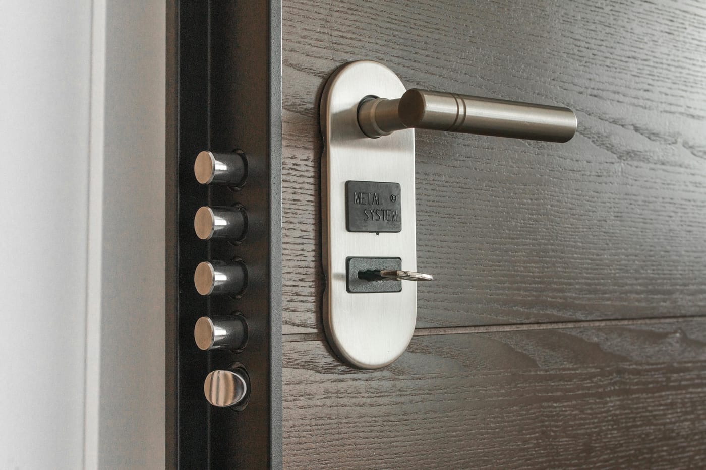 Metal door lock cylinder with key inserted in keyhole showing deadbolt security mechanism for lock change service in Washington DC