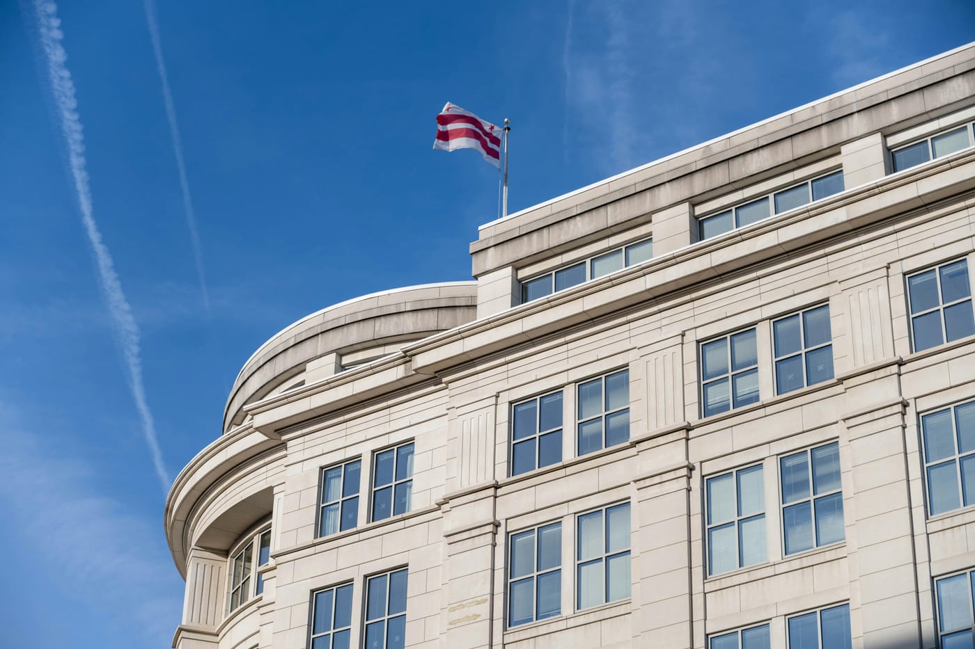 White art-deco building with curved facade flying the Washington DC flag representing Northwest DC locksmith service coverage