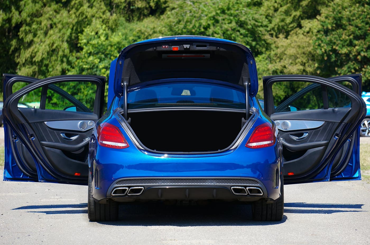 Blue sedan with open trunk and doors in a parking area, trunk lockout service Washington DC