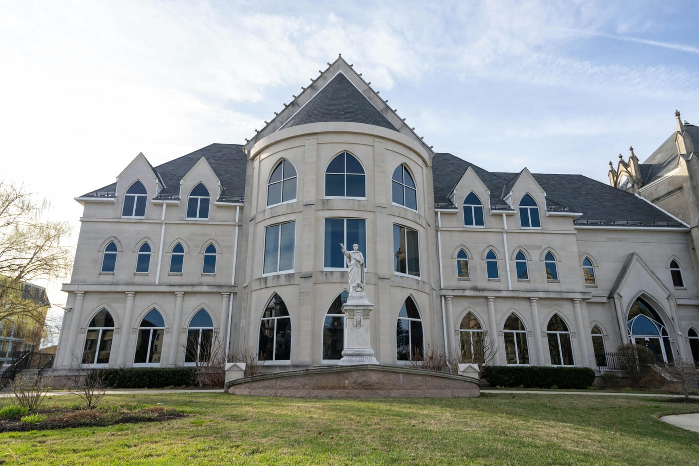 Pale campus building with a large arched central window