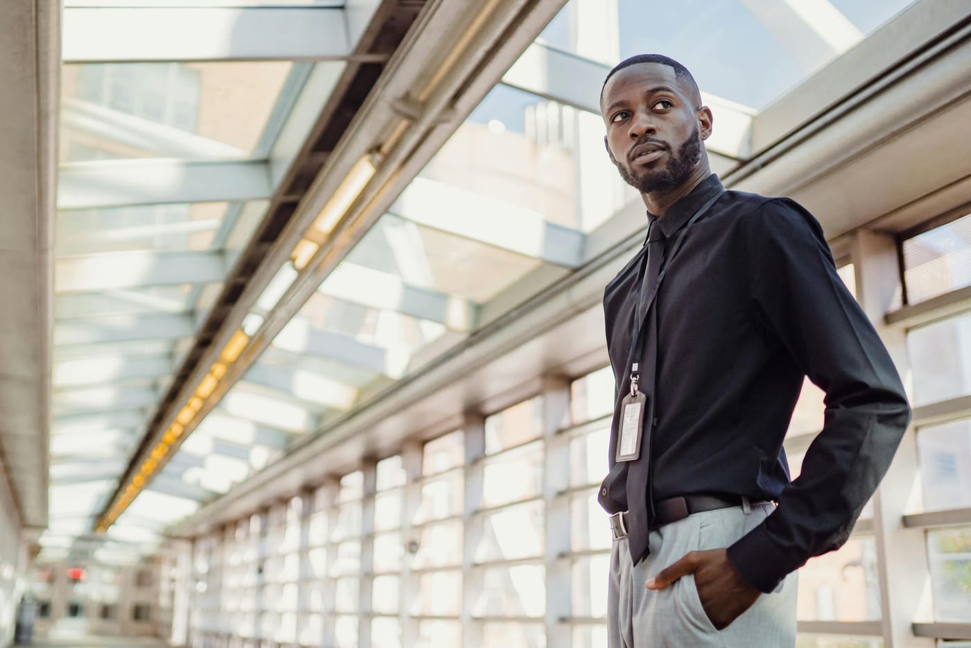Man standing in a modern glass-roofed corridor