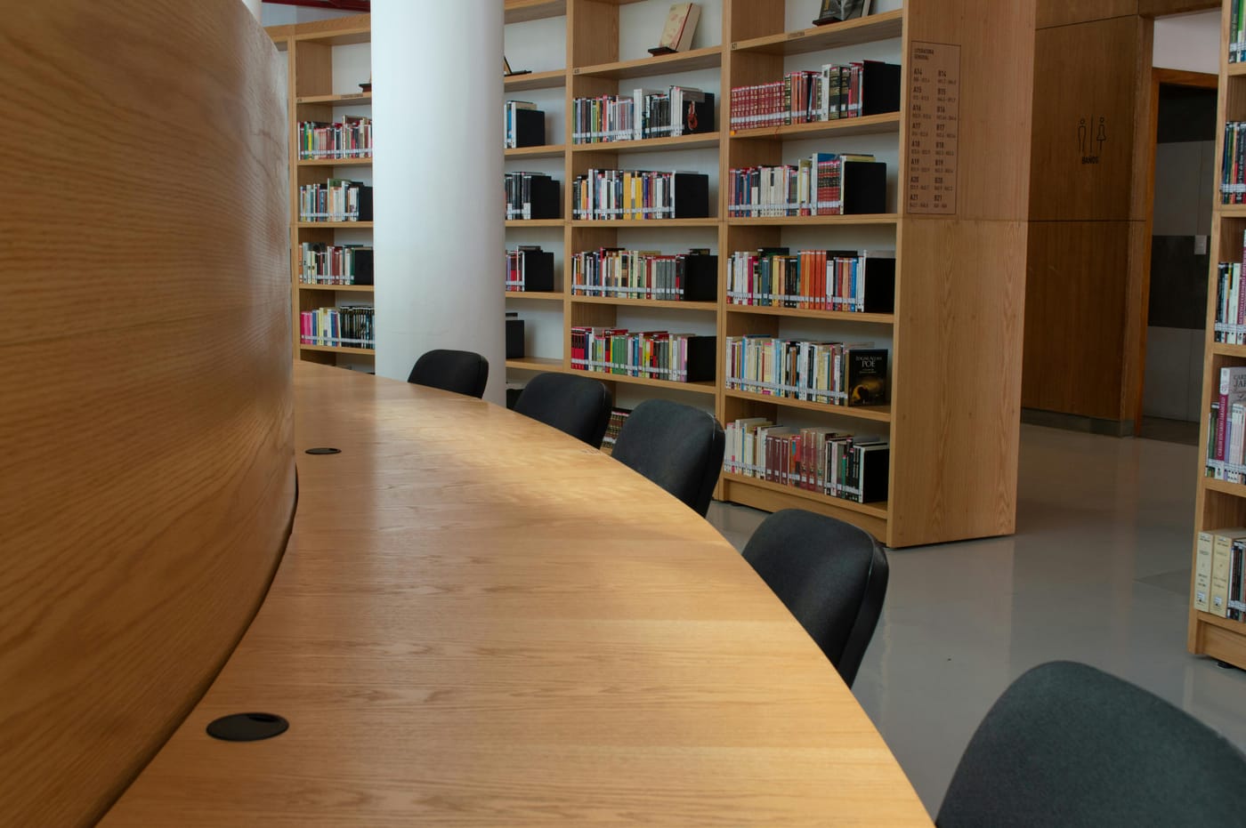 Library reading table and shelves of books