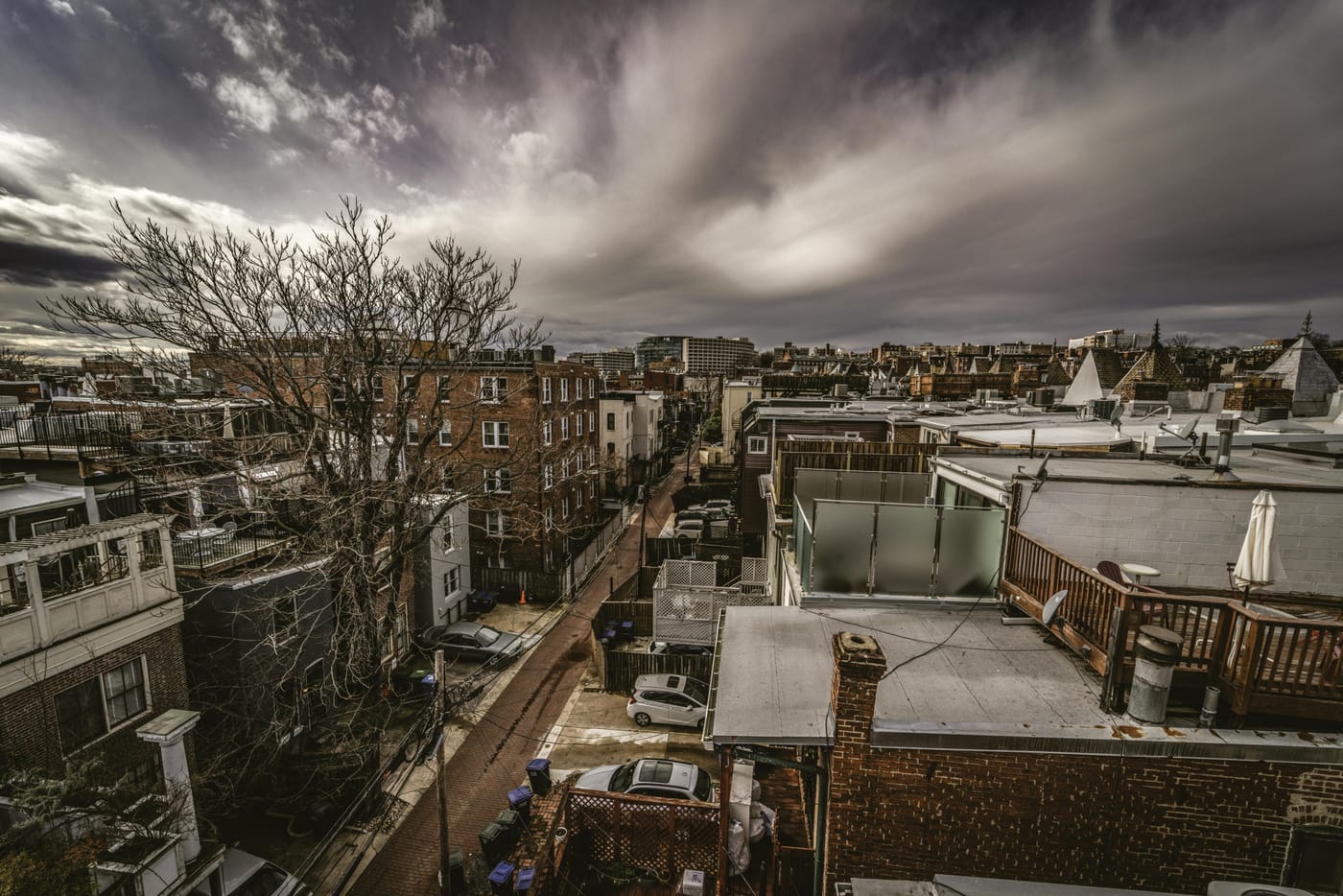 View across dense city rooftops beneath storm clouds