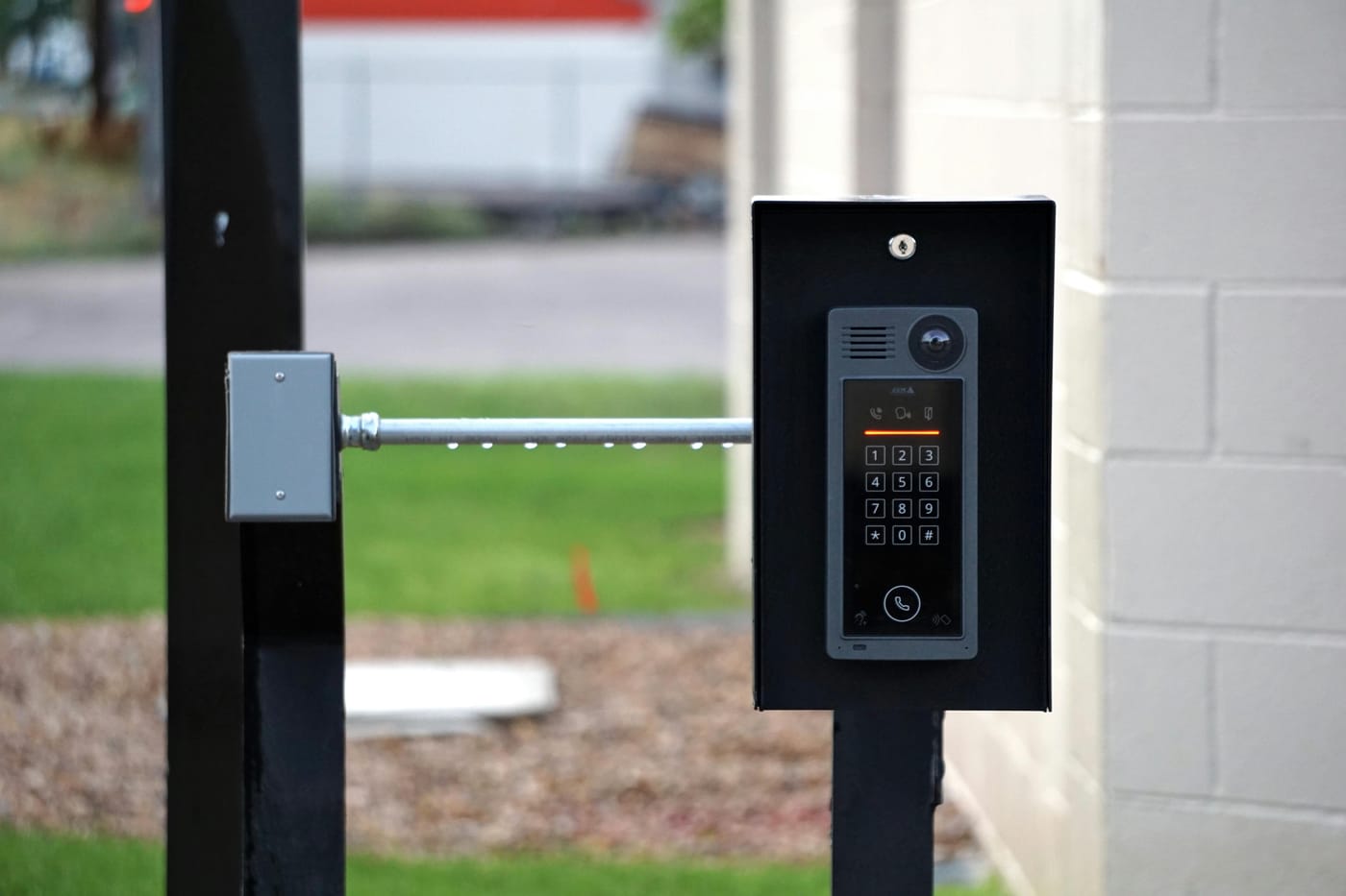 Outdoor intercom mounted beside a metal gate