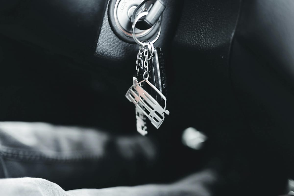 Car keys on a ring beside an ignition showing standard automotive key configuration