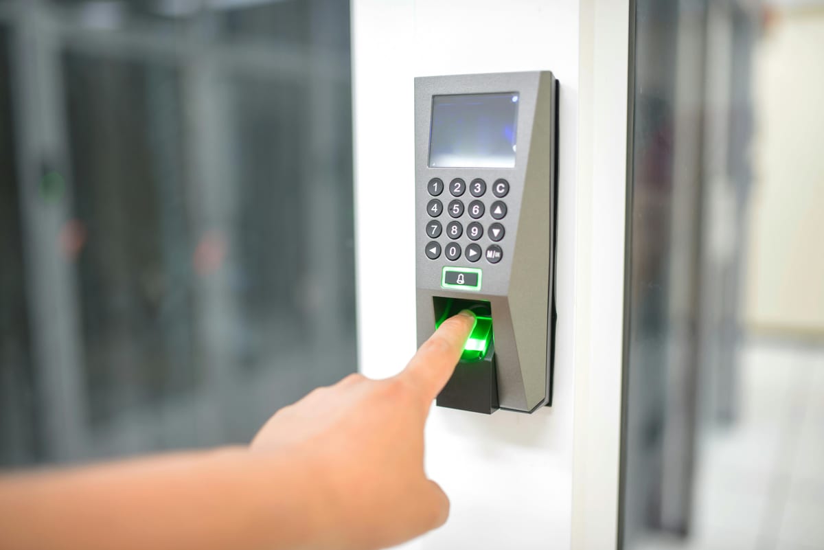 Person using biometric fingerprint scanner with keypad to enter a secure Washington DC data center