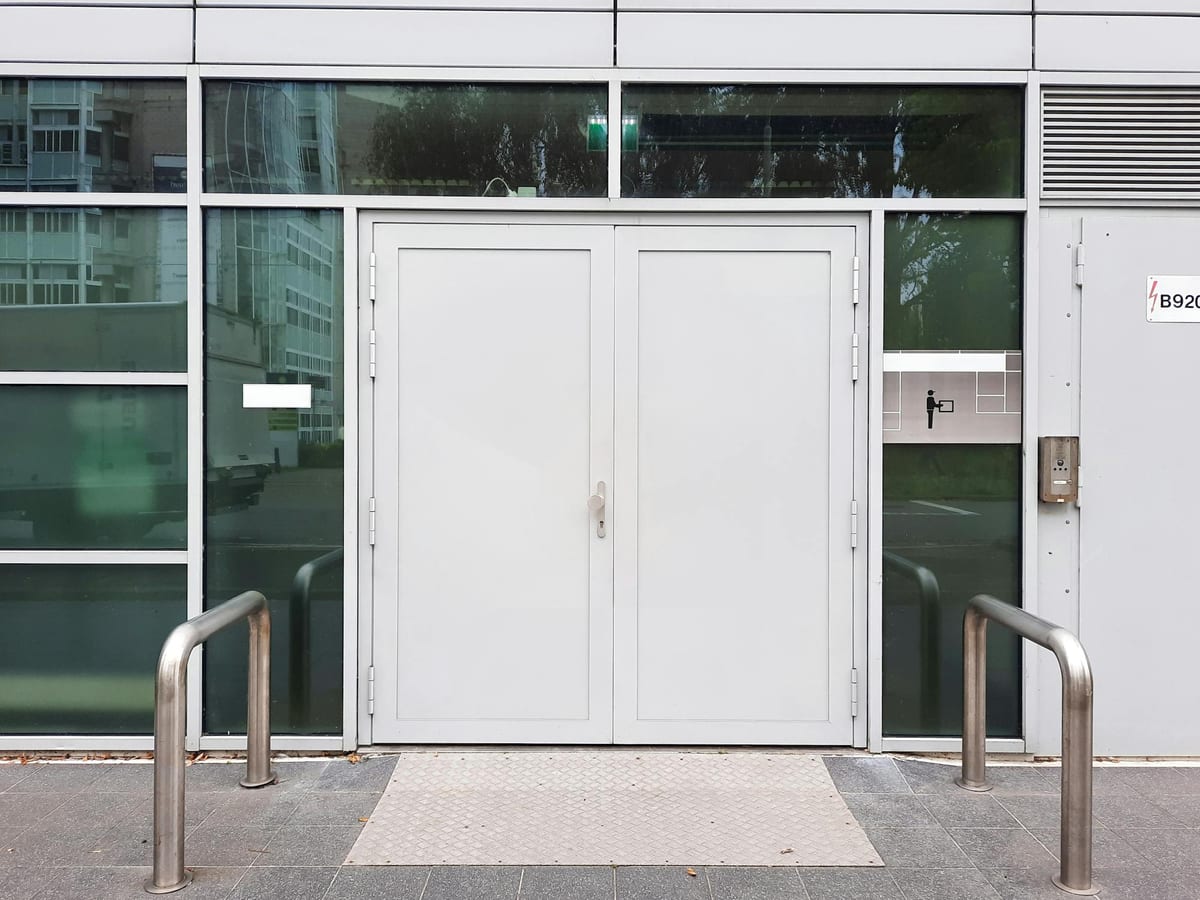 Modern glass building entrance with double doors and clean architecture