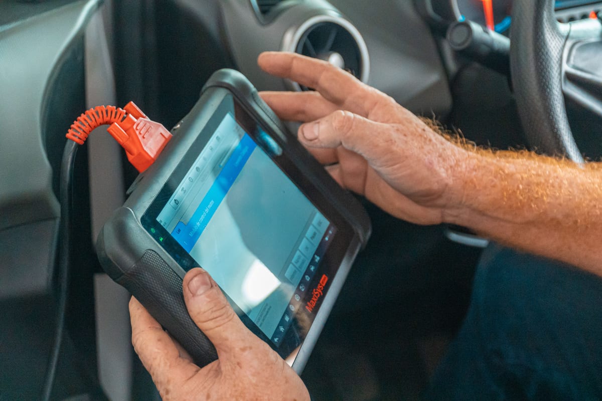 An automotive key programmer screen connected via OBD port showing key programming status