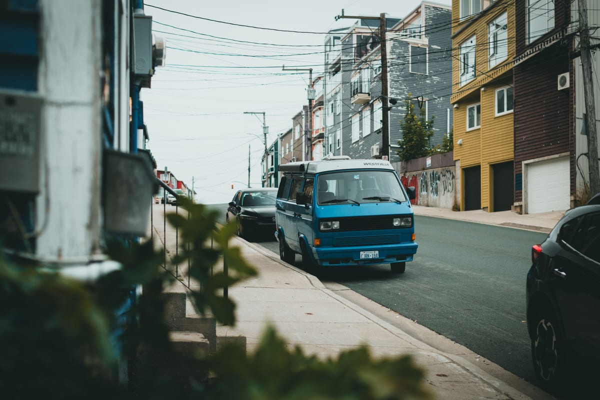 A service van parked on a rowhouse-lined residential street