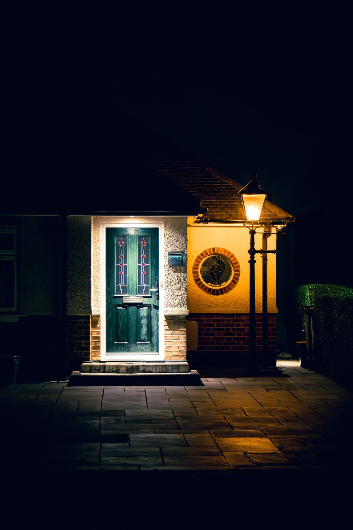 Cozy suburban front door illuminated by warm porch lighting at night