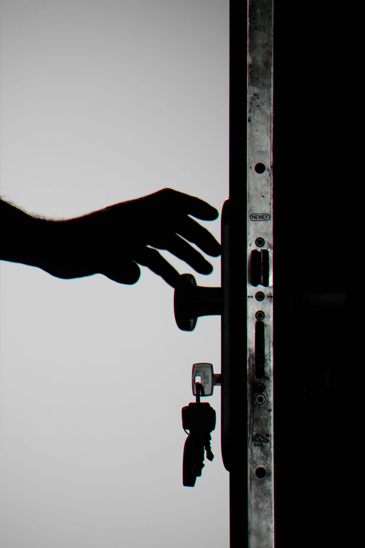 Person silhouetted at locked residential door during an evening home lockout