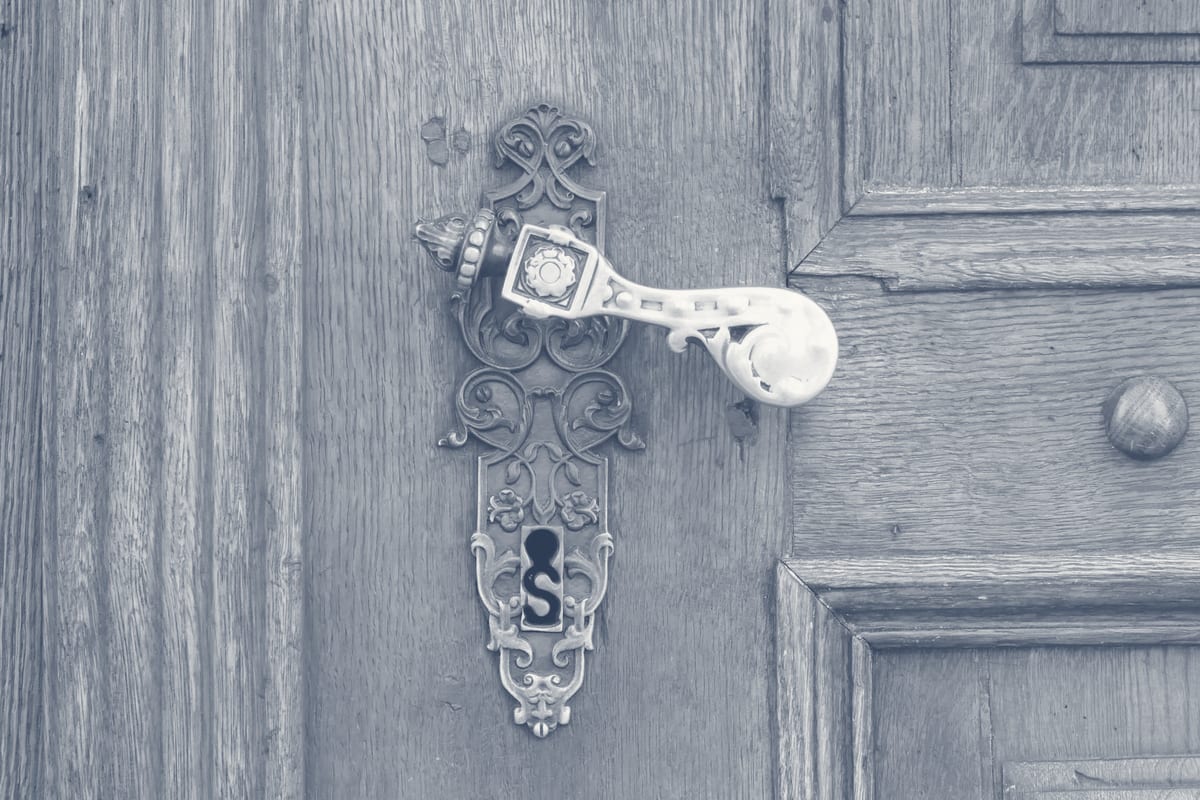 Original ornate brass door handle and keyhole on a Georgetown historic home unchanged by smart lock installation