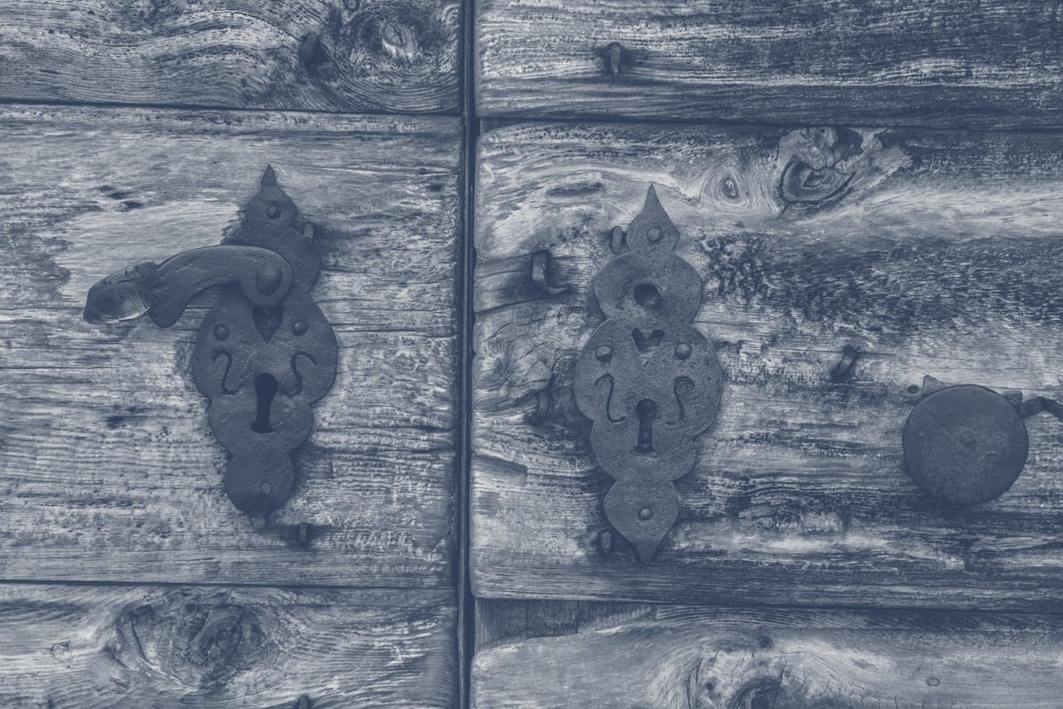 Rustic keyhole and vintage metal lock plate on wooden door