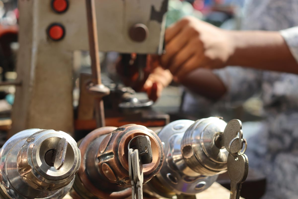 Locksmith key cutting machine with lock cylinders on a shop bench
