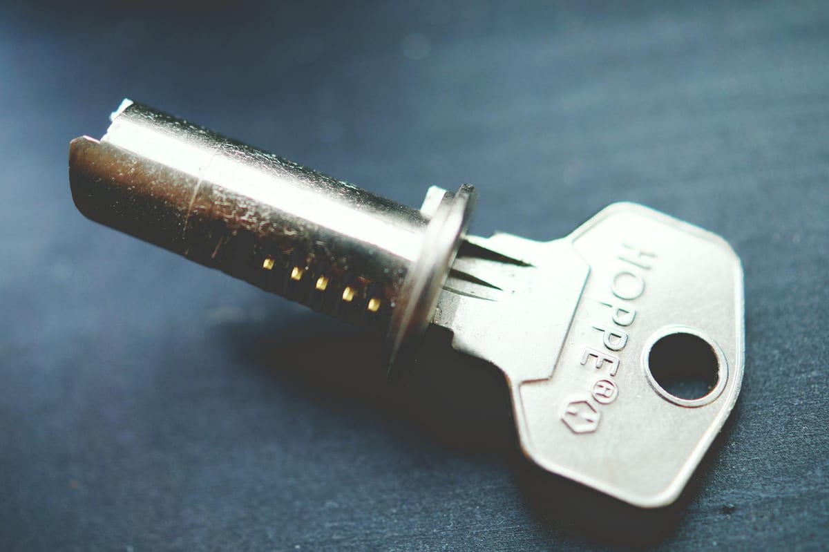 High-security lock cylinder with metallic key showing restricted keyway detail